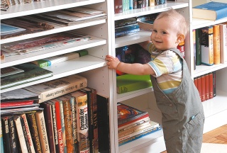 Babys erste Stehversuche vor einem Bücherregal