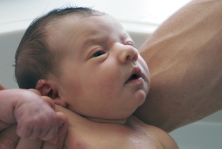 Neugeborenes in den Armen seiner Mutter