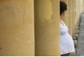 Schwangere Frau hinter Säulen