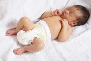 Baby in Windel auf dem Rücken liegend