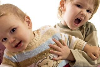 Grosser Bruder hält Baby im Arm