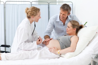 Ärztin, schwangere Mutter und Vater