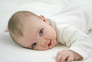 Baby auf Bauch liegend mit offenen Augen
