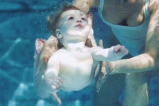Baby schwimmt mit seiner Mutter