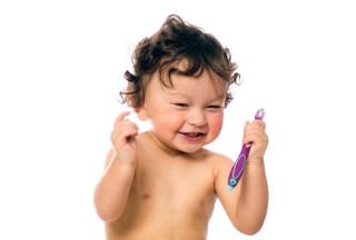 Baby mit Zahnbürste und Schnuller