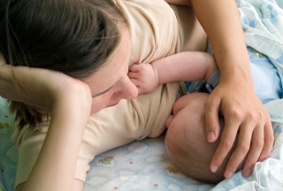 Mutter stillt ihr Baby im Liegen